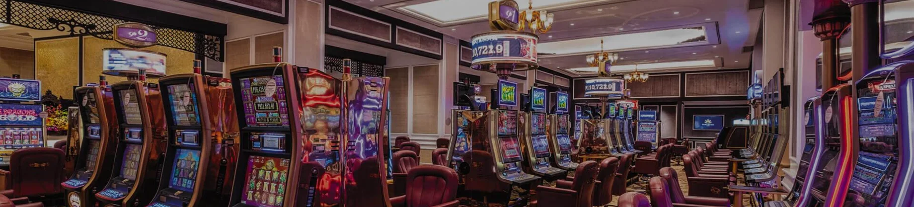 きらびやかな照明と鮮やかなディスプレイがカジノのスロットマシンホールを照らす